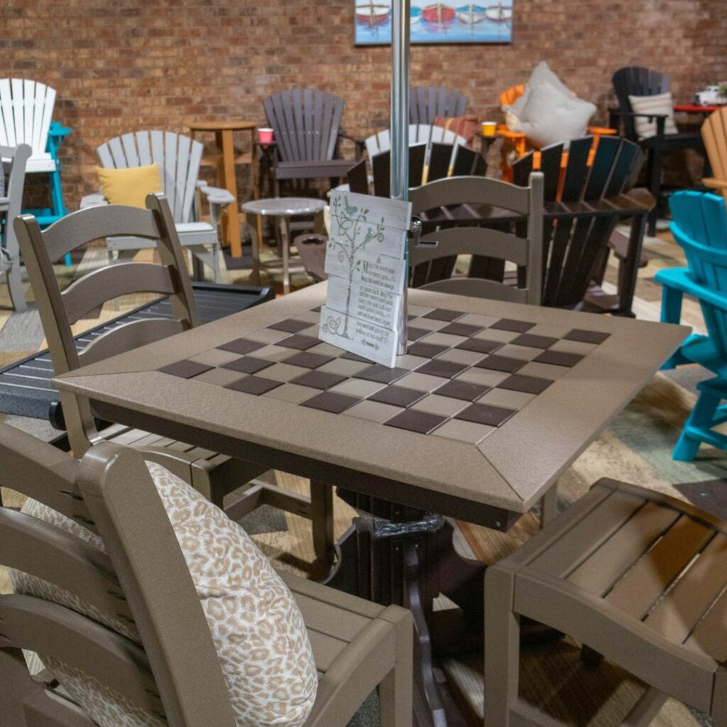 a checkered table with chairs and an umbrella in the middle