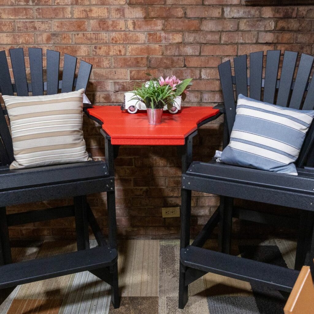 two tall navy chairs with pillows and a table in between them