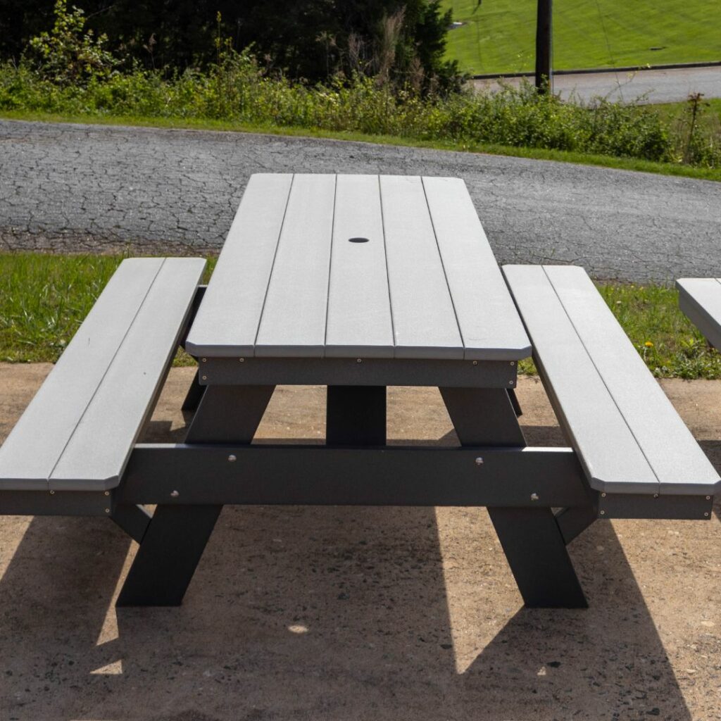 Gray picnic table with benches on outdoor pavement